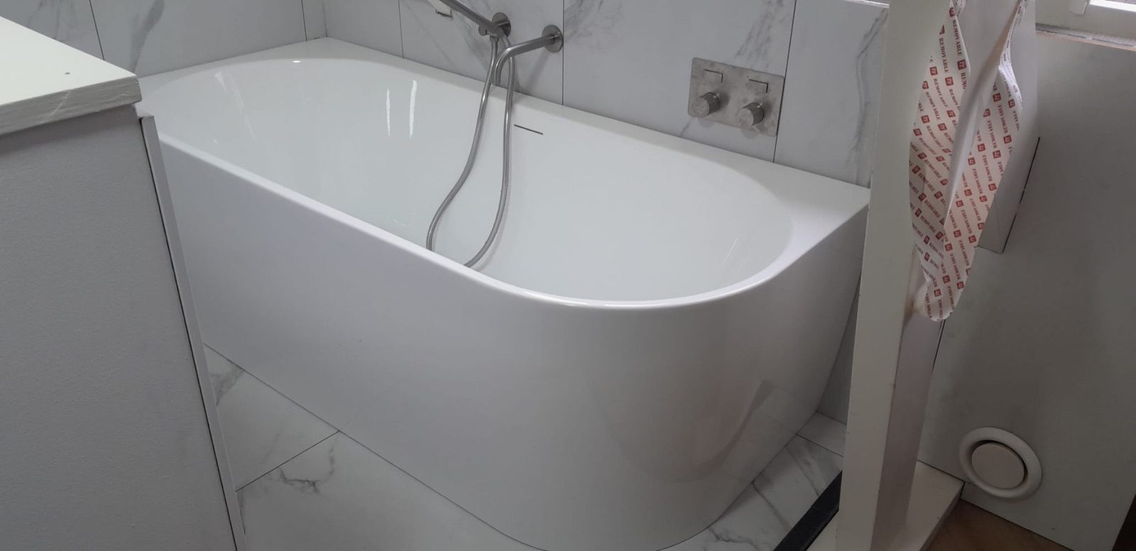 Ligbad met wandkranen en marmerlook tegels