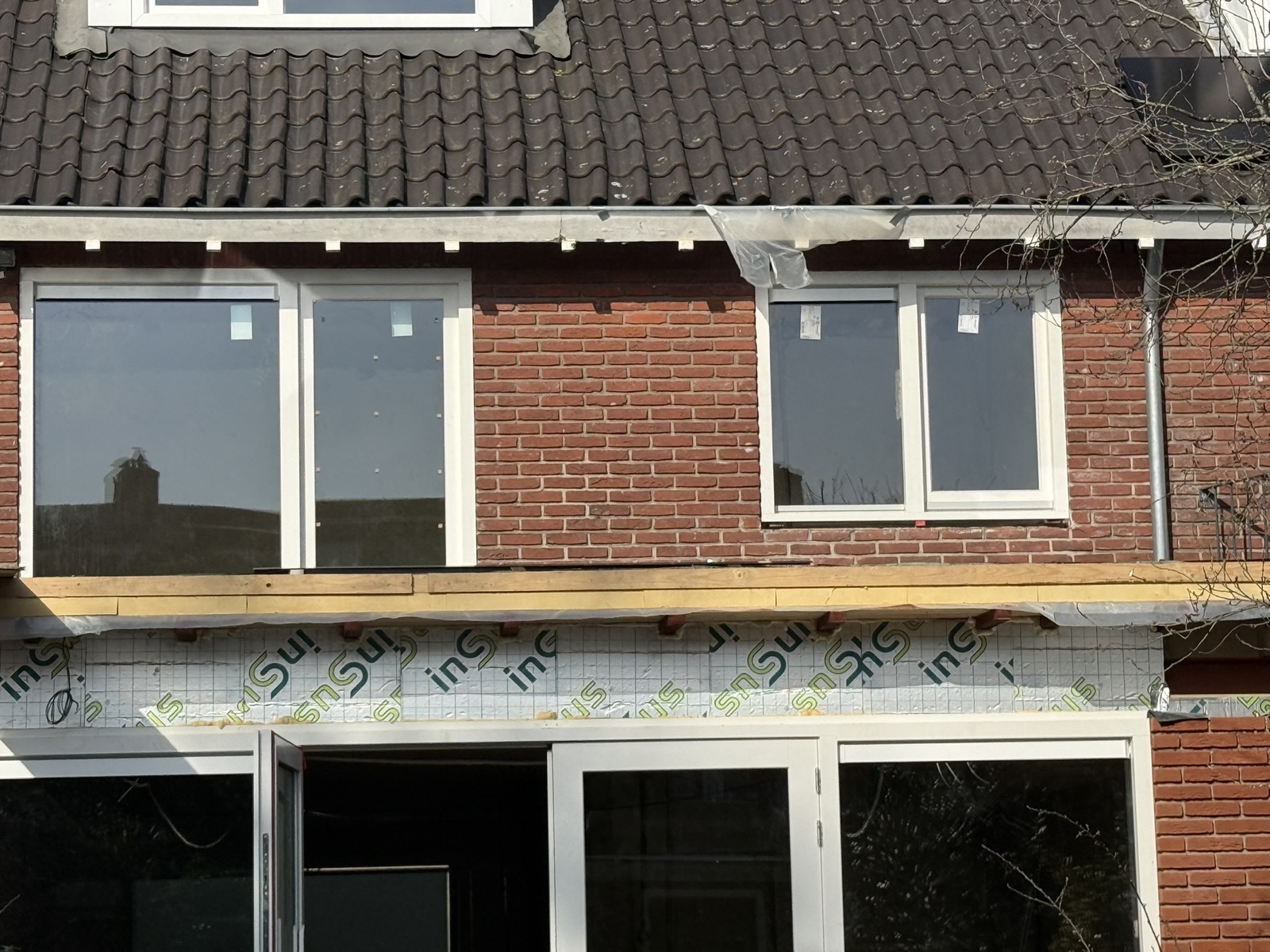 Achtergevel met nieuwe kozijnen tijdens aanbouwfase