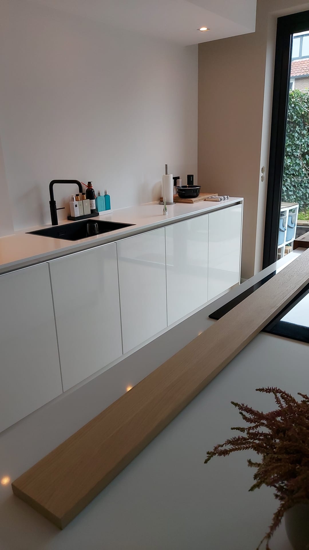 Witte keuken met zwart spoelbak en lange werkbladlijn