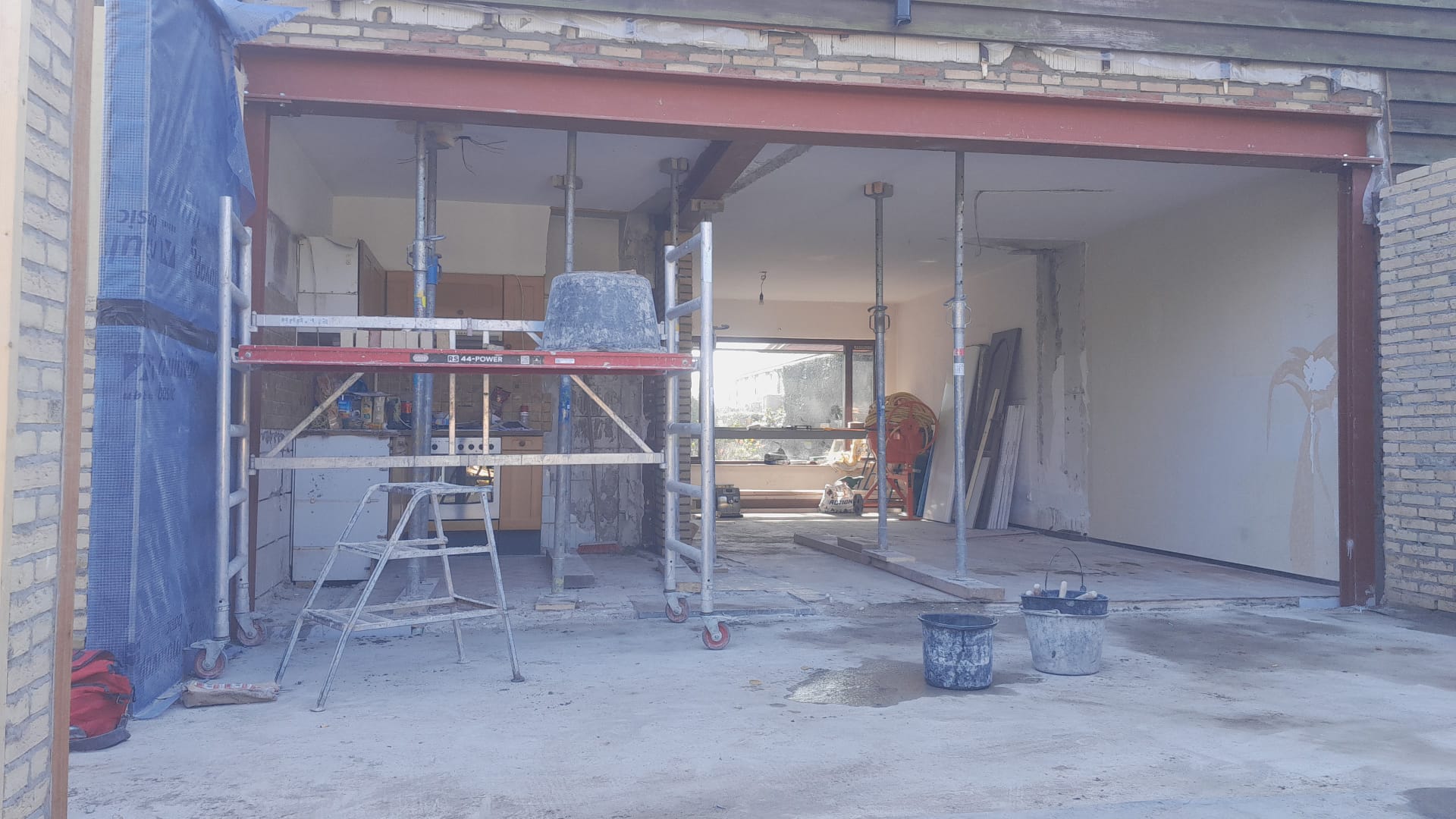 Grote gevelopening met stalen balk en tijdelijke stempels door De Bouw Baron