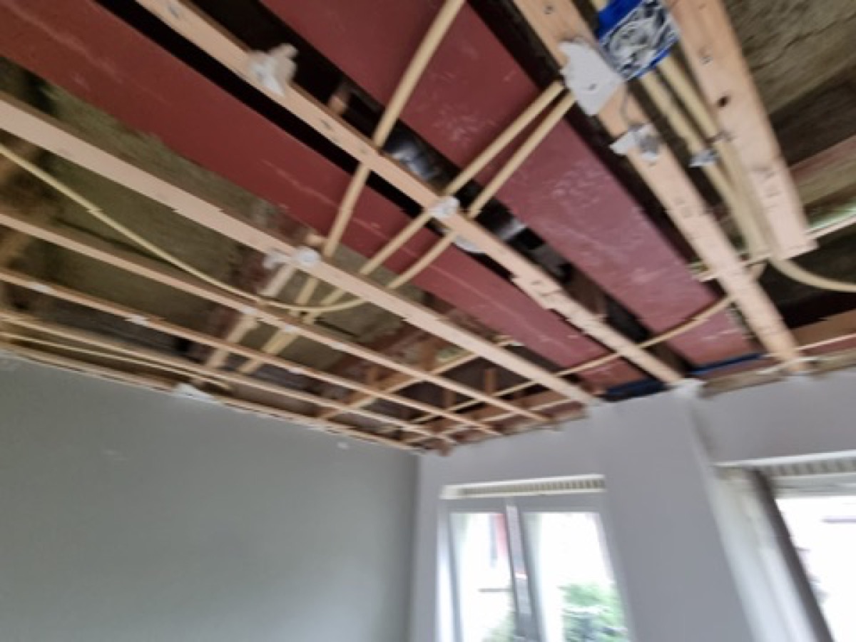 Stalen balk en leidingwerk in open plafond door De Bouw Baron