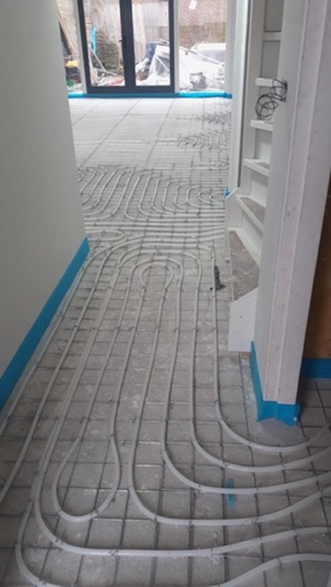 Vloerverwarming op netten met blauwe randisolatie door De Bouw Baron